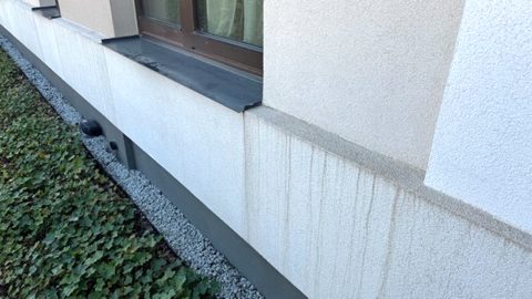 Ślady spływu wody na powierzchni elewacji