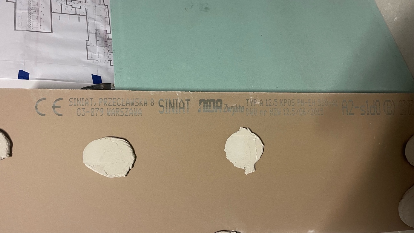Fragment zdemontowanej okładziny z punktami klejenia.