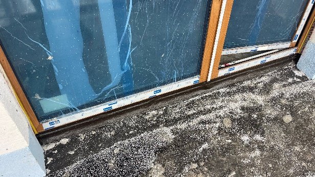 Dolna strefa połączenia drzwi balkonowych z ościeżem, widok zewnętrzny.